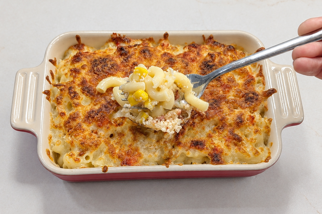 Hong Kong style baked Demae Iccho cheese macaroni topped with a golden broiled Mozzarella layer and bacon in a ceramic dish