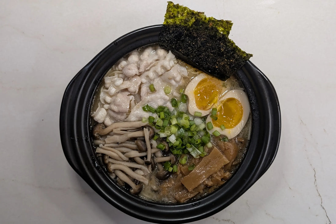 One-pot Nissin Demae Iccho Kyushu Tonkotsu bar noodles served directly in a pot topped with pork belly, shimeji mushrooms, and jammy soy-marinated egg