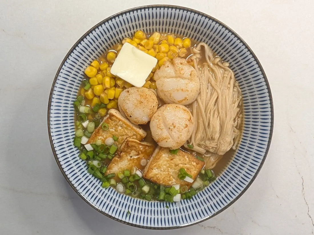 10-Minute Hokkaido Miso Tonkotsu Ramen topped with butter-seared scallops, pan-fried tofu, enoki mushrooms, sweet corn, and a melting pat of butter in a black bowl.
