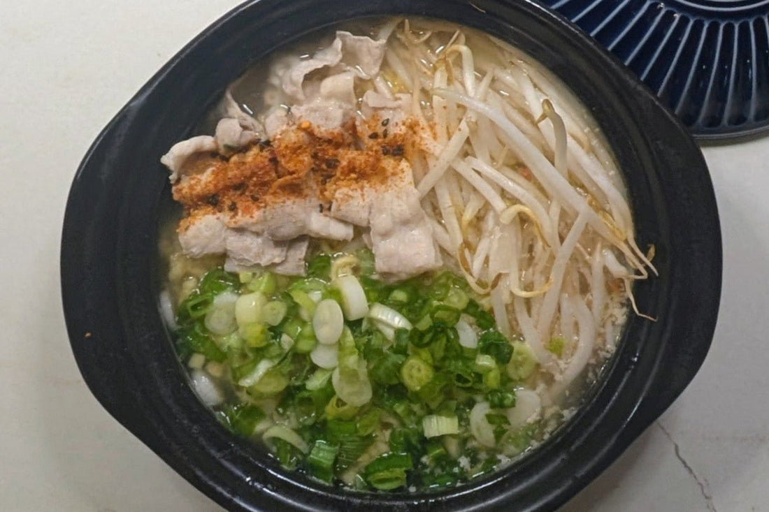 One-pot Tonkotsu ramen in a claypot with poached thin pork belly slices, fresh bean sprouts, and chopped scallions using Nissin Demae Iccho 100% Hokkaido Wheat noodles.