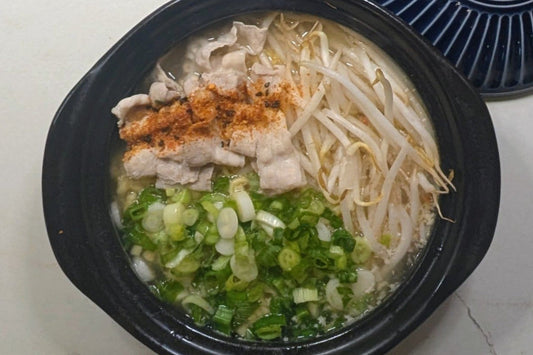 One-pot Tonkotsu ramen in a claypot with poached thin pork belly slices, fresh bean sprouts, and chopped scallions using Nissin Demae Iccho 100% Hokkaido Wheat noodles.