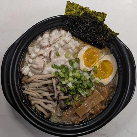 One-pot Nissin Demae Iccho Kyushu Tonkotsu bar noodles served directly in a pot topped with pork belly, shimeji mushrooms, and jammy soy-marinated egg